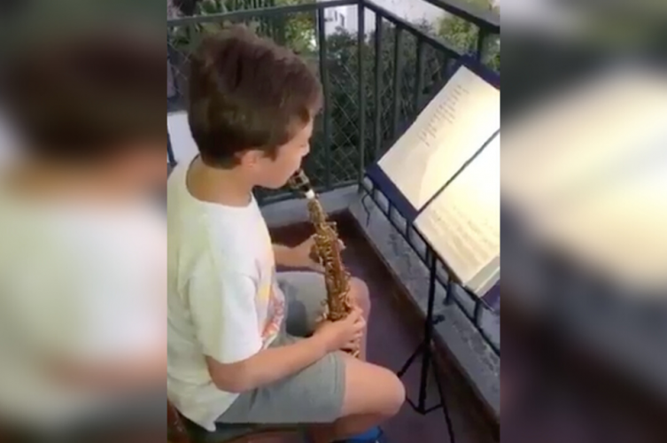 Tocó el Himno argentino en el balcón y se ganó el aplauso de todos sus vecinos